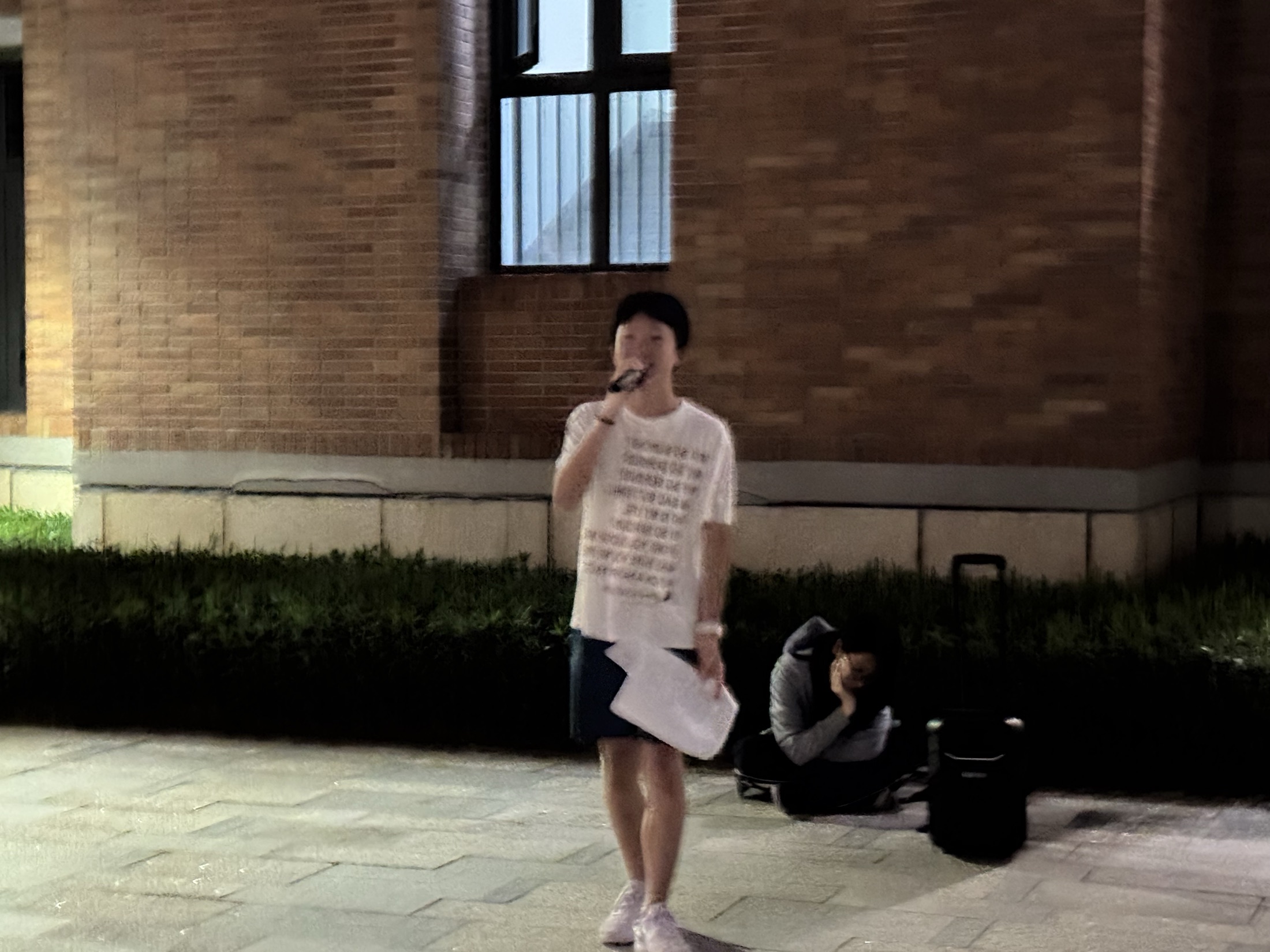 Ben performing with a microphone outdoors at night
